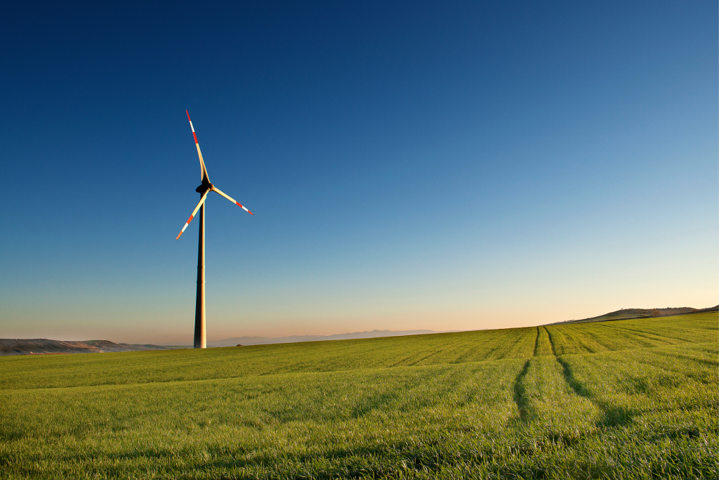 Image of a lone wind turbine standing in a field